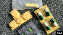 កញ្ចប់​ថ្នាំ​ដែលអ្នក​ជំងឺទូទៅ​ទទួលបានតាម​ឱសថស្ថាន​នានា​​ក្រោយ​ពេលគេ​រៀប​រាប់​អំពី​អាការៈ ជំងឺ​ផ្តាសាយ​​ដោយ​​ពុំភ្ជាប់​វេជ្ជបញ្ជា​​ ថ្នាំនេះ​សម្រាប់​ផឹក​៤ដង​ ឬ១ថ្ងៃកន្លះ​ដែល​ផ្សំតាម​ការសុំរបស់អ្នកទិញ​, ក្នុង​នេះ​មាន​យ៉ាងហោច​ណាស់​​ថ្នាំផ្សះ​មួយ​មុខ​។ (ខាន់​ សុគុំមនោ/ VOA) 