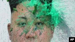 FILE - A liquid-filled balloon thrown by a North Korean defector bursts on a portrait of leader Kim Jong Un during a protest rally in Seoul, South Korea. The United Nations has renewed efforts to have the country release information on abductees and defectors. 
