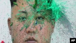 Người đào tị Bắc Triều Tiên ném bóng chứa sơn lên chân dung lãnh tụ Kim Jong Un trong một cuộc biểu tình phản đối Bình Nhưỡng tại Seoul, ngày 30 tháng 3, 2016.