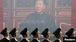 Soldiers of People's Liberation Army (PLA) are seen before a giant screen as Chinese President Xi Jinping speaks at the military parade marking the 70th founding anniversary of People's Republic of China, on its National Day in Beijing, China October 1, 2