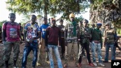 In this Aug. 28, 2014, photo an Anti-Balaka group that defends the Christian neighborhood near the Church of the city stands for a photo in Boda, Central African Republic. More than 5,000 people have died in sectarian violence in the Central African Republic since December, according to an Associated Press tally. (AP Photo/Sylvain Cherkaoui)