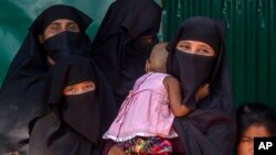Rohingya Muslim women along with their children, who have crossed over from Myanmar into Bangladesh, wait for the arrival of Queen Rania of Jordan, at Kutupalong refugee camp in Bangladesh, Oct. 23, 2017. 