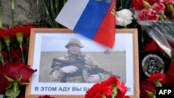 A portrait of Yevgeny Prigozhin is seen amid flowers at a makeshift memorial in front of the Private Military Company (PMC) Wagner Centre in Saint Petersburg, on August 25, 2023.