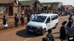 Healthcare workers and members of the community form an honor guard to mark the service and commitment of their colleague, Duduzile Margaret Mbonane, who died from COVID-19, during her funeral in Thokoza east of Johannesburg, South Africa, July 23, 2020.