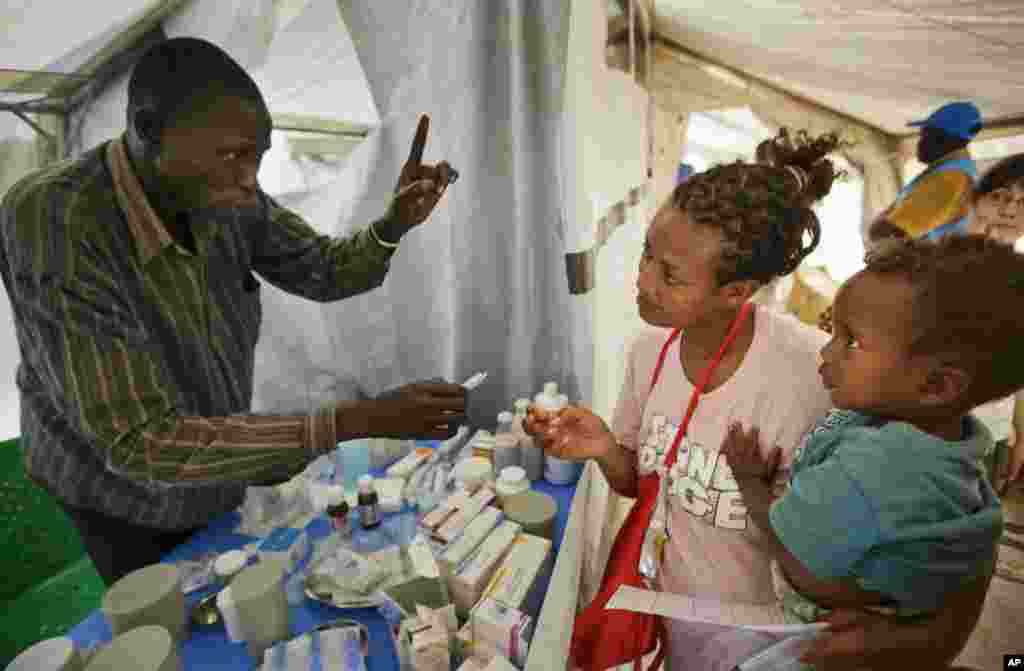Yared, 2, is held by mother Madhn who fled from the town of Bor a few days ago, as she receives medicine for her child at a Medecins Sans Frontieres (MSF) medical tent at a United Nations compound.