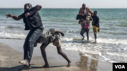 Gambian journalists Sheriff Bojang Jr., left, and Abdoulie John arrive in Banjul for the first time in years. Bojang has been in exile since 2007 and John since 2013 — this is their fist time being home in years. (Photos by Ricci Shyrock/VOA)