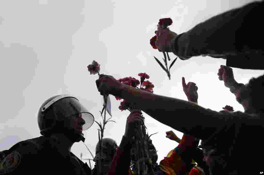 People offer flowers to a civil guard at the entrance of a sports center, assigned to be a referendum polling station by the Catalan government in Sant Julia de Ramis, near Girona, Oct. 1, 2017.