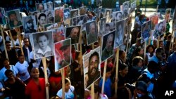 មនុស្ស​ម្នា​កាន់​រូប​របស់​លោក​អតីត​ប្រធានាធិបតី​គុយបា Fidel Castro ក្នុង​ការ​ដើរ​ក្បួន​មួយ​ដើម្បី​ប្រារព្ធ​ខួប​មរណភាព​១ឆ្នាំ​ ចាប់​តាំង​ពី​ពេល​លោក​ត្រូវ​បាន​គេ​បញ្ចុះ​រួច​មក​ នៅ​ក្នុង​ក្រុង Santiago ប្រទេស​គុយបា កាលពី​ថ្ងៃទី៤ ខែធ្នូ ឆ្នាំ២០១៧។