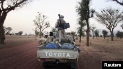 Militiaman from the Ansar Dine Islamic group ride on an armed vehicle between Gao and Kidal, northeastern Mali, June 12, 2012.