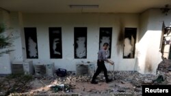 ប៉ូលិស​ម្នាក់​ដើរកាត់​បង្អួច​ដែល​ត្រូវ​បាន​រង​ការខូចខាត​ បន្ទាប់​ពី​មាន​ការ​ធ្វើ​បាតុកម្ម​ ក្រោយ​ពី​ការ​ប្រកាស​លទ្ធផល​នៃ​ការ​បោះឆ្នោត​ជាតិ​នៅ​ក្រុង​ហ្សាការតា ប្រទេស​ឥណ្ឌូនេស៊ី កាល​ពី​ថ្ងៃ​ទី​២៣ ខែ​ឧសភា ឆ្នាំ​២០១៩។ 