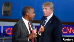 FILE - Republican U.S. presidential candidates Dr. Ben Carson and businessman Donald Trump talk during a commercial break in the Republican presidential candidates debate, Sept. 16, 2015. 