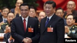 Presiden China Xi Jinping (kanan) menjabat tangan Perdana Menteri China yang baru terpilih, Li Keqiang, disambut tepuk tangan meriah para delegasi Kongres Rakyat Nasional ke-12 di Beijing (15/3).