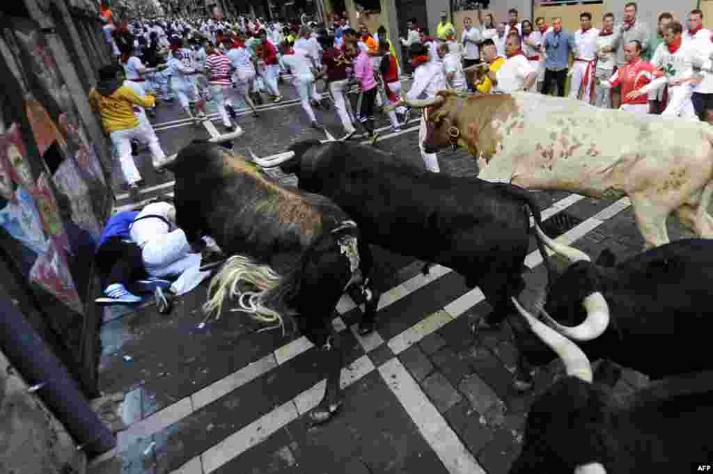 Para peserta berlarian dalam festival dikejar banteng di kota Pamplona, Spanyol utara.