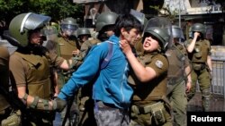 A demonstrator is detained during a protest against Chile's government in Concepcion, Chile