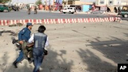 Afghan security personnel carry an injured man after an attack near the Kabul Airport, in Kabul, Afghanistan, July 22, 2018.