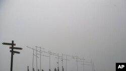 Pilgrims walk past sculptures indicating the direction of St. James' Way in El Perdon mountain, near to Pamplona northern northern Spain, June 1, 2021.