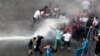 Lebanese activists are sprayed by riot police using water cannons during a protest against the ongoing trash crisis, in downtown Beirut, Lebanon, Aug. 23, 2015. 