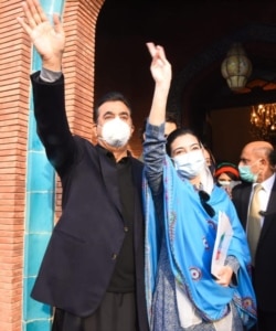Aseefa Bhutto-Zardari makes a victory sign for the crowd. Standing next to her is Pakistan's former Prime Minister Yousaf Raza Gilani.