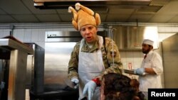 A U.S. Army soldier serves Thanksgiving meal to his comrades at the Resolute Support headquarters in Kabul, Afghanistan November 22, 2018.