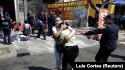 Seorang perempuan menenangkan temannya setelah seorang kerabat ditembak orang tak dikenal di luar bengkel di Mexico City, Meksiko, 12 Februari 2021.(Foto: Luis Cortes/Reuters)