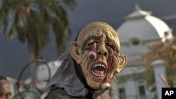 A masked reveler passes the earthquake damaged National Palace during carnival celebrations in Port-au-Prince,Mar 6 2011
