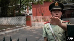 Seorang polisi paramiliter di luar Kedutaan Belgia di Beijing, 19 Juni 2019.