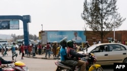FILE - A passenger rides on a fuel-powered moto-taxi in Kigali, Rwanda, July 30, 2017. Rwanda is introducing electric motorcycles, with more than 600 being built for use in the country.