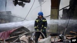 Petugas pemadam kebakaran memadamkan api setelah serangan roket Rusia di Kyiv, Ukraina, Rabu, 30 Agustus 2023. Lebih dari 20 roket dan drone telah ditembak jatuh oleh sistem pertahanan udara di Kyiv pada hari itu. (Foto: AP)