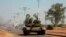 A military tank patrols along one of the main roads in the South Sudanese capital Juba, Dec. 16, 2013. The South Sudanese president declared a curfew in the capital Juba on Monday after clashes overnight between rival factions of soldiers.