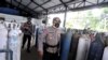 Para polisi menjaga distribusi oksigen di tempat isi ulang di tengah lonjakan kasus COVID-19 di Mengwi, Badung, Bali, 22 Juli 2021. (Foto: Fikri Yusuf/Antara Foto via Reuters