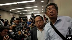 FILE - Freed Hong Kong bookseller Lam Wing-kee, right, is accompanied by pro-democracy lawyer Albert Ho after giving a news conference in Hong Kong, June 16, 2016. 
