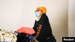 Tennis player Naomi Osaka arrives at Adelaide Airport ahead of the Australian Open tennis tournament, Jan. 14, 2021. The tournament will proceed despite the discovery of three coronavirus cases that have put 47 players into quarantine for two weeks.