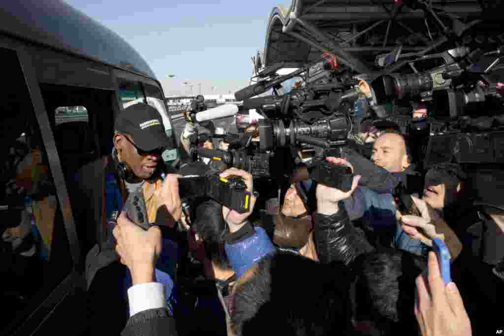 Mantan bintang NBA Dennis Rodman (kiri) tiba di bandar udara Beijing, China (19/12). (AP/Ng Han Guan)
