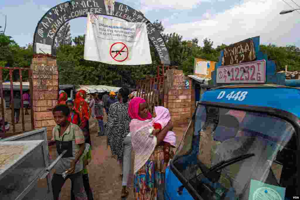 The busy entrance of a crowded school that has been converted into a camp for displaced families in Shire, June 11, 2021 (Yan Boechat/VOA)