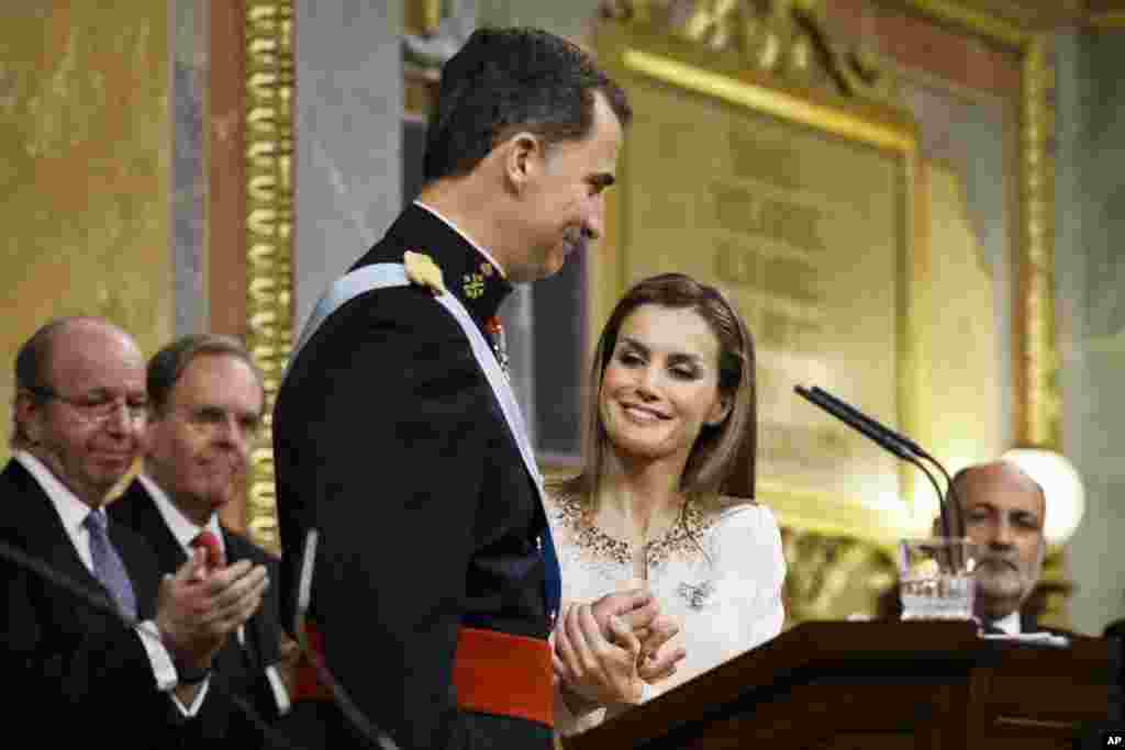 Spain&#39;s Queen Letizia holds the hands of her husband King Felipe VI during the swearing-in ceremony at the Spanish Parliament. Felipe is being formally proclaimed monarch after 76-year-old King Juan Carlos abdicated to enable younger royal blood to rally a country beset by economic problems, including an unemployment rate of 25 percent.