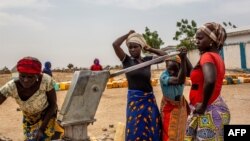 FILE - Women fetch water at the Minawao refugee camp near Gadala, Cameroon, March 3, 2020.