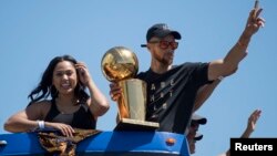 Stephen Curry (avec le trophée des champions NBA), sa femme Ayesha Curry, Oakland, Californie, le 15 juin 2017.