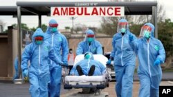 미국 휴스턴 메모리얼메디컬센터에서 방역복을 입은 의료진이 신종 코로나바이러스 감염 의심 환자를 옮기고 있다.