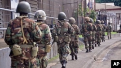 Liberian soldiers walk through streets to prevent panic as fears of the deadly Ebola virus spread in the city of Monrovia, Liberia, Friday, Aug 1, 2014. U.S. health officials warned Americans not to travel to the three West African countries hit by the wo