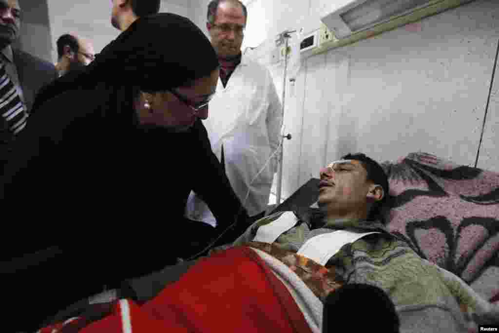 Dr. Maha Rabat, Minister of Health and Population, speaks to an injured man receiving medical treatment at a hospital after an explosion outside the police headquarters in Mansoura, Dec. 24, 2013.