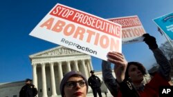FILE - Abortion-rights activists protest outside the U.S. Supreme Court, during the March for Life in Washington, Jan. 18, 2019. 