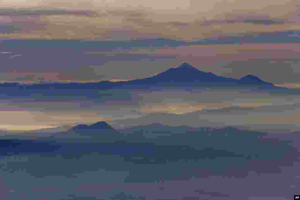 Pico de Orizaba, atau pegunungan Citlaltepetl, tertutup kabut pagi, terlihat dari sebuah pesawat Angkatan Laut Meksiko pada misi pemantauan gunung berapi di Meksiko.