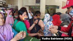 Relawan membagikan sabun cuci tangan kepada pedagang pasar Gedhe Solo, 21 Maret 2020. (Foto: VOA/ Yudha Satriawan)