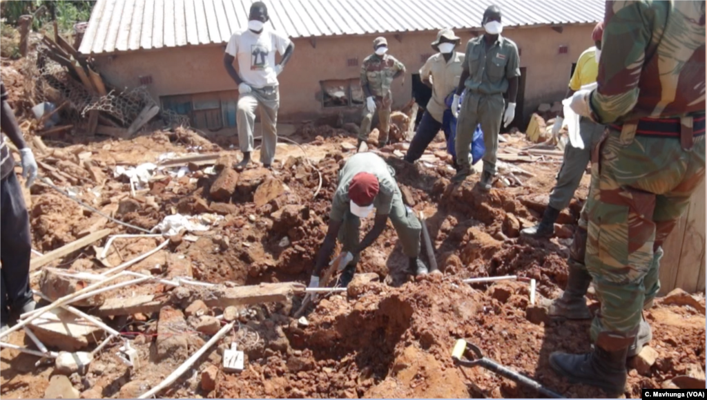 Zimbabwe army officials exhume a body March 26, 2019, in Chimanimani district ahead of the arrival of South African police sniffer dogs.