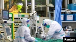 Staf medis (mengenakan pakaian pelindung) merawat pasien dengan pneumonia yang disebabkan oleh virus corona baru di Rumah Sakit Zhongnan, Universitas Wuhan, provinsi Hubei, China, 28 Januari 2020.