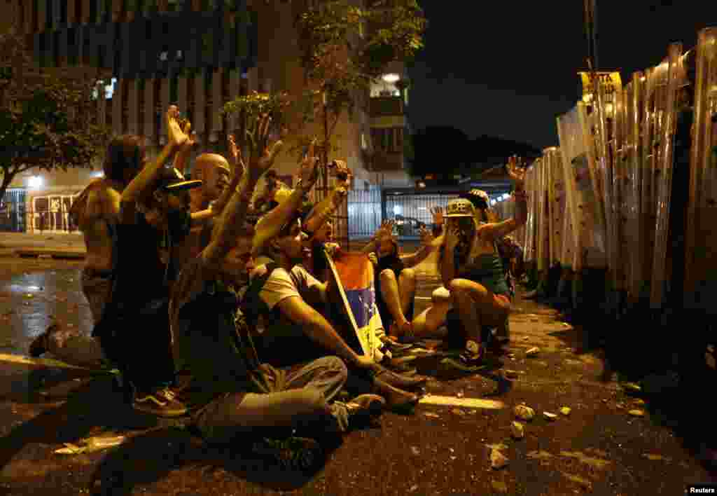 Supporters of opposition leader Henrique Capriles stand in front of riot police as they demonstrate for a recount of the votes in Sunday&#39;s election, in Caracas, April 15, 2013.&nbsp;