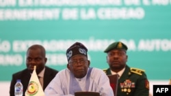 Le président de la Communauté économique des États de l'Afrique de l'Ouest et président du Nigéria, Bola Ahmed Tinubu, réagit en s'adressant au chef d'État et de gouvernement de la Cédéao à Abuja le 30 juillet 2023.