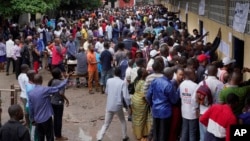 Hundreds of Congolese voters who have been waiting at the St. Raphael school in the Limete district of Kinshasa Dec. 30, 2018, storm the polling stations after the voters listings were finally posted five hours after the official start of voting. 