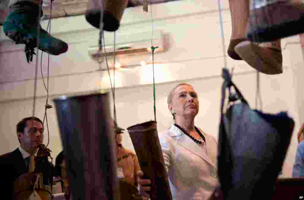 Clinton, center, watches an exhibition of artificial limbs on her tour at the Cooperative Orthotic Prosthetic Enterprise Center (COPE), in Vientiane, Laos, July 11.