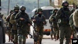 Israeli forces search for a Palestinian gunman in the village of Bruqin near the West Bank town of Salfit, March 17, 2019. 